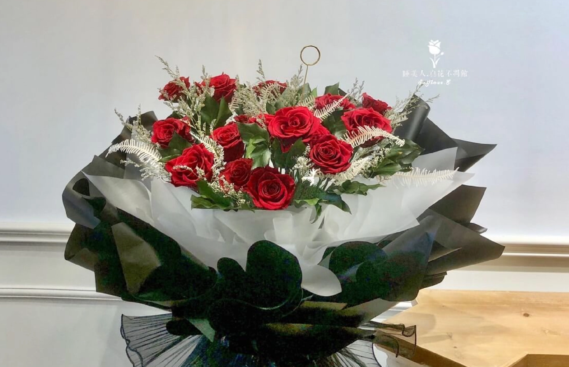 睡美人紅玫瑰花束以黑色包裝紙包覆