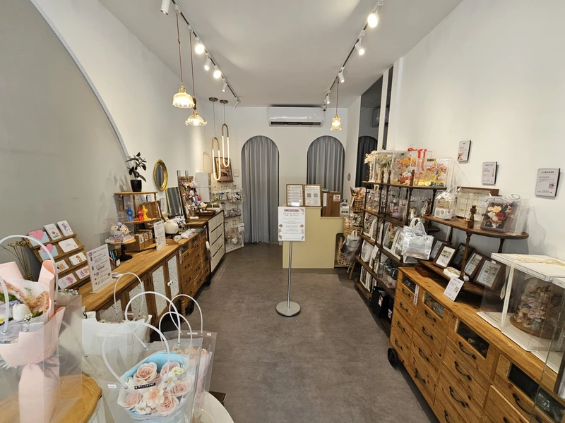 睡美人真花不凋館店內走道與兩側木櫃陳列永生花束與相框